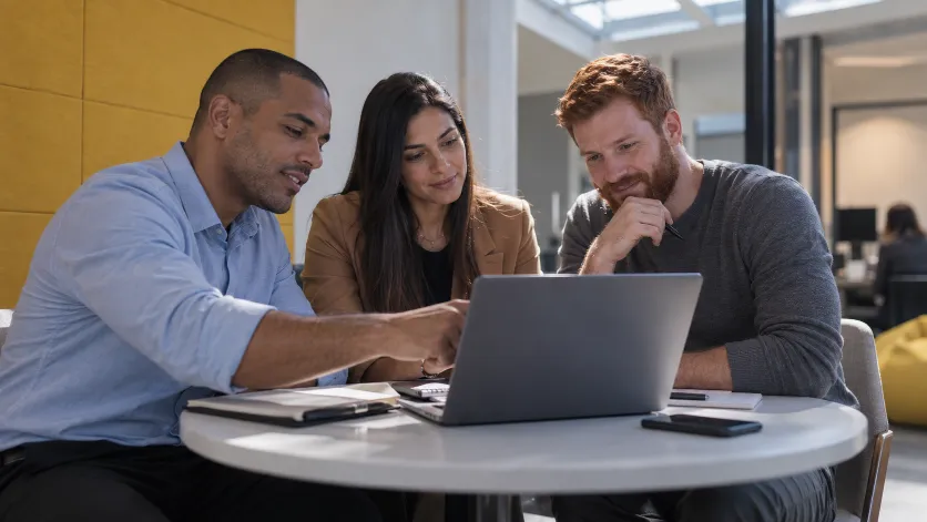 Três advogados olhando juntos a tela de um notebook